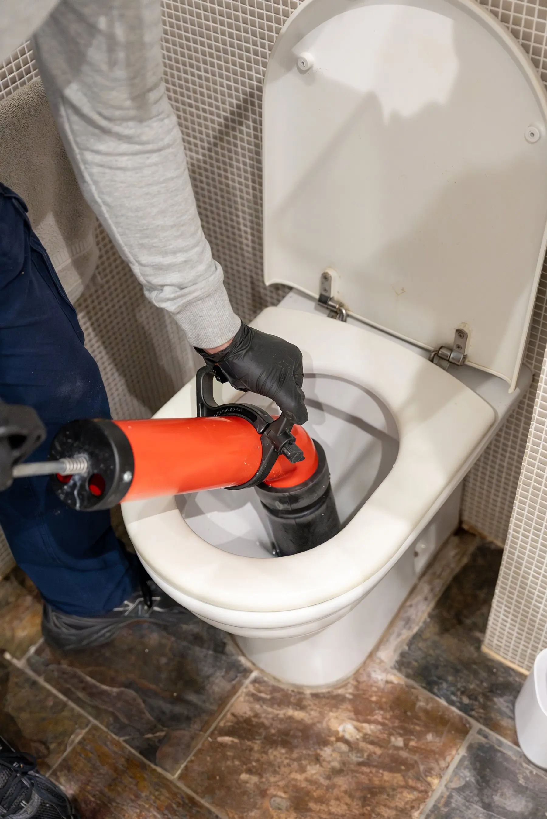 A Plumbwell plumber clearing a blocked toilet