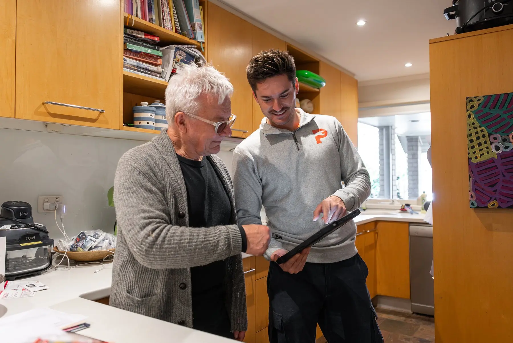 A Plumbwell plumber going through a quote with a customer