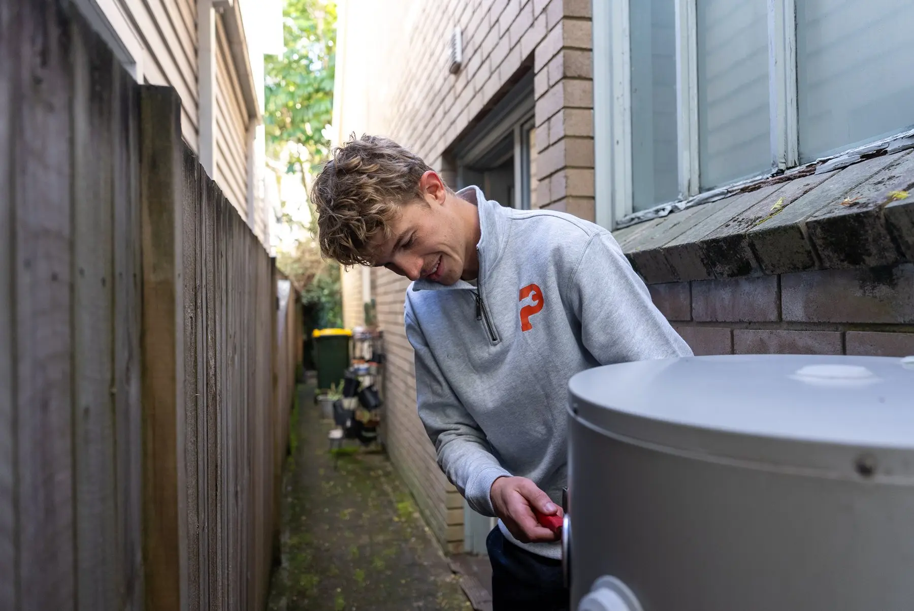 A Plumbwell plumber inspecting a hot water storage tank