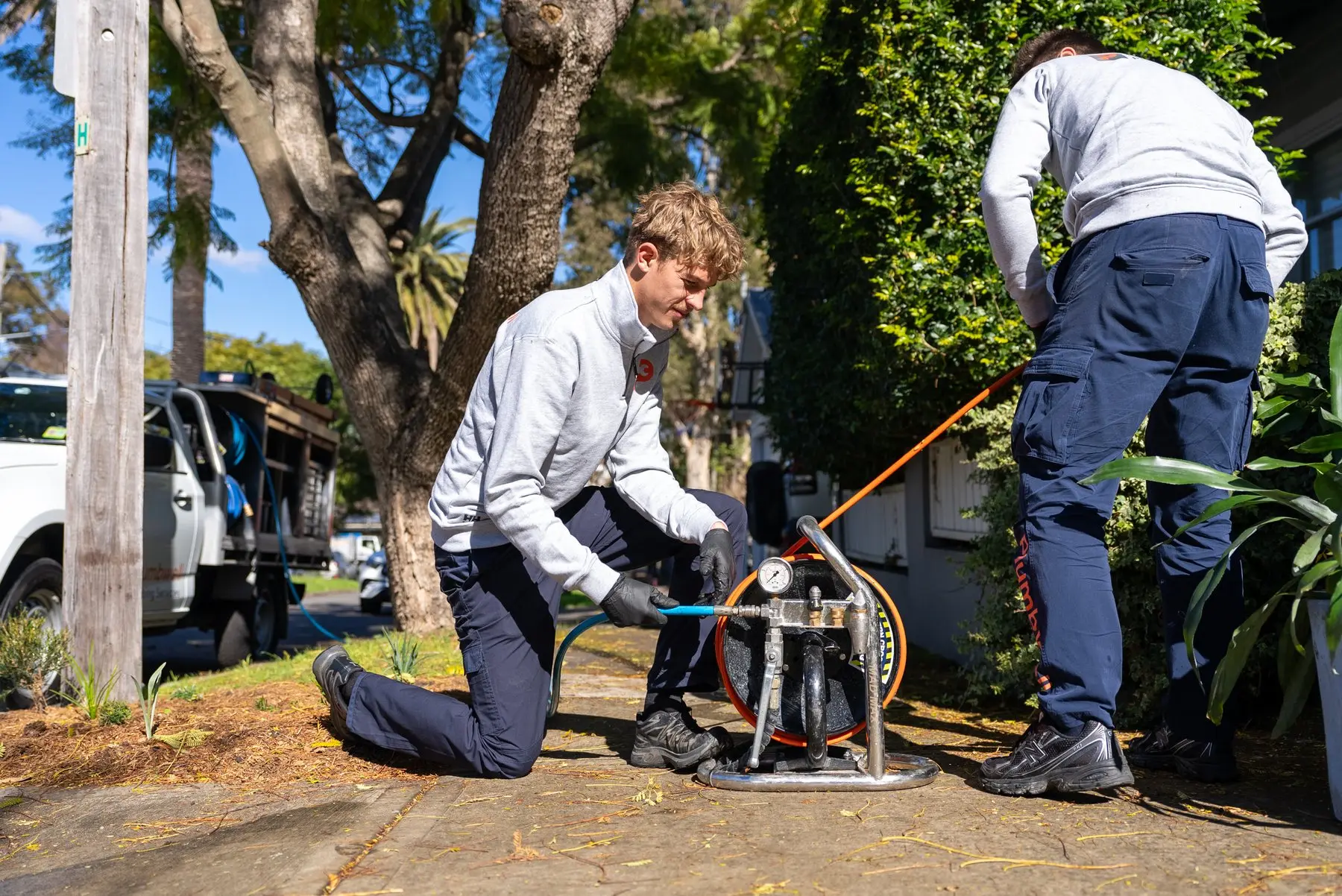 A Plumbwell plumber running drain clearing equipment