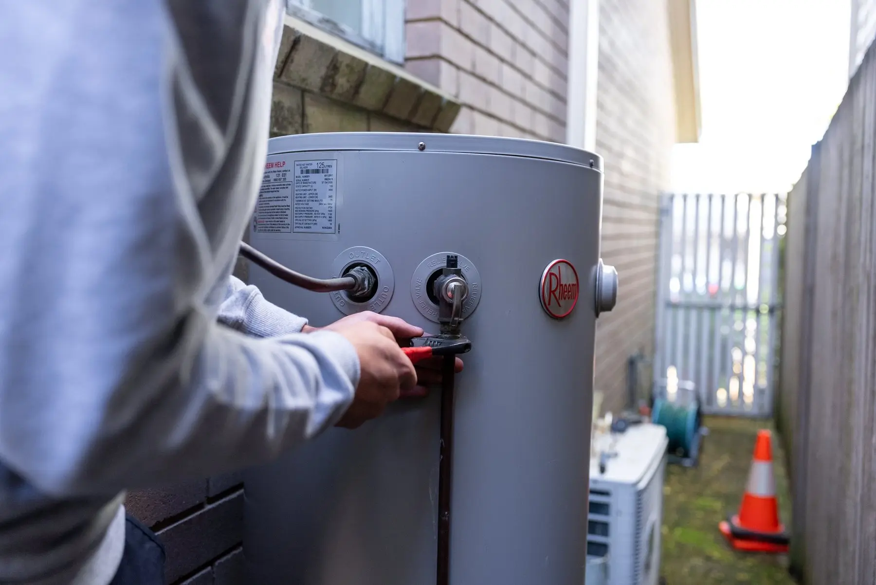 A Plumbwell plumber servicing an electric hot water cylinder