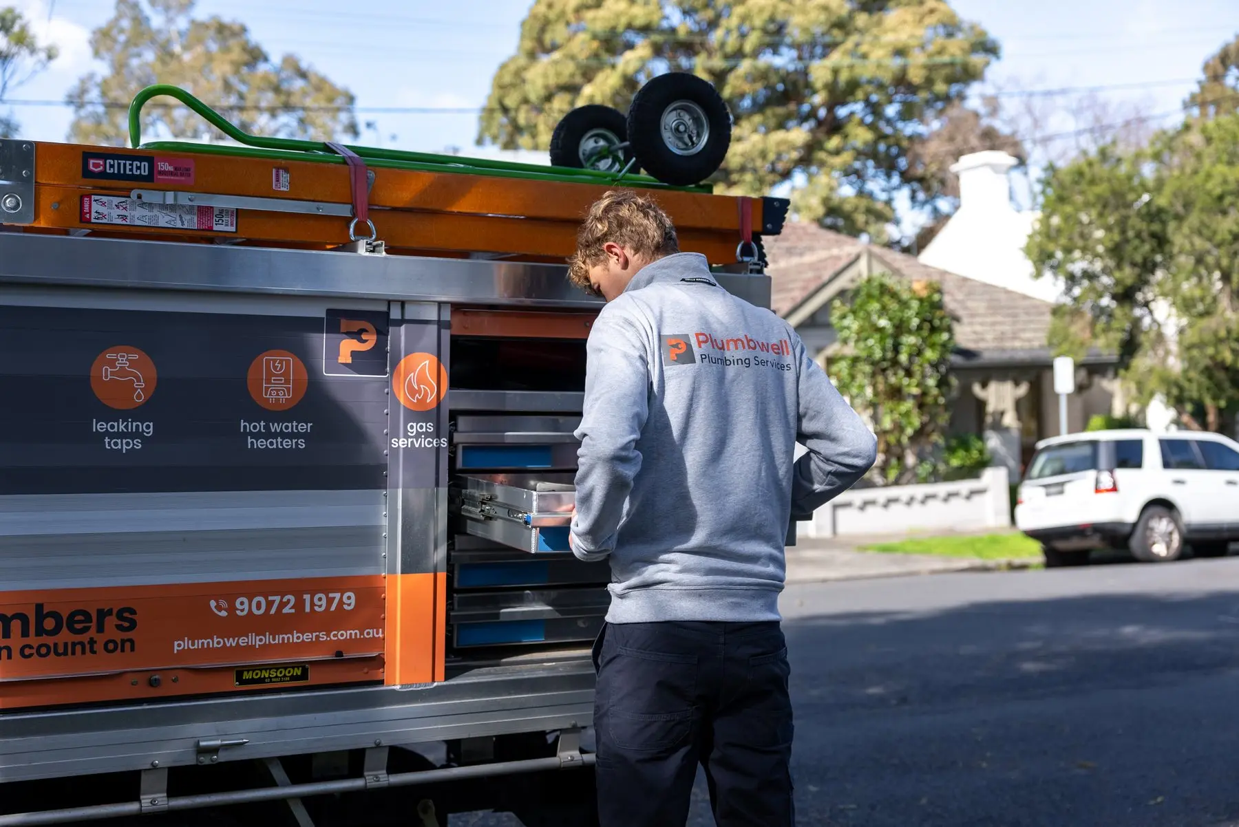 A Plumbwell plumber unloading a replacement hot water system