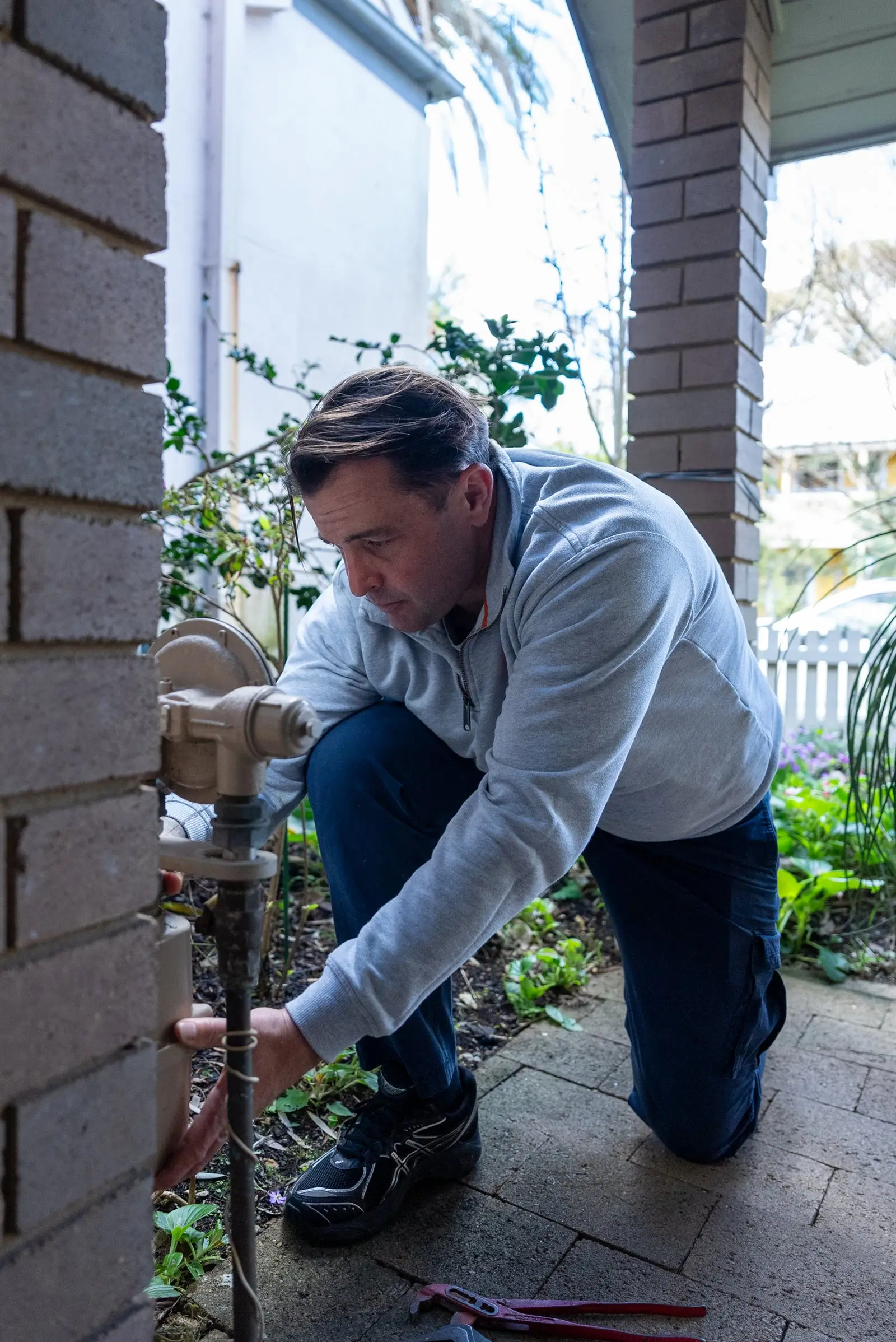 A Plumbwell plumber working on a gas meter