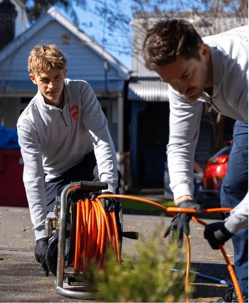 Plumbwell plumbers setting up a drain jetter in a Sydney backyard